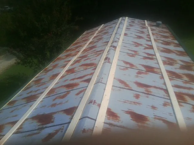 Rusted metal roof panels with new wood purlins before replacement — Storm Damage Roof Repair in Ridgeville by Roofing Brothers