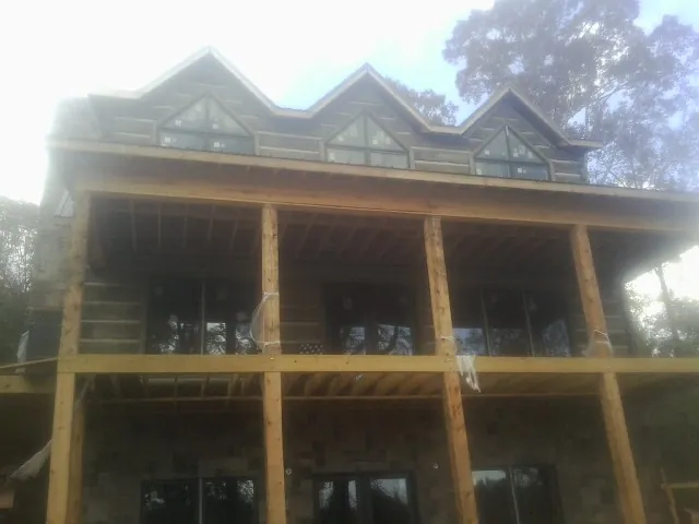 Dormers and porch framing on a large log home under construction — Roof Coating work by our crew in Ridgeville